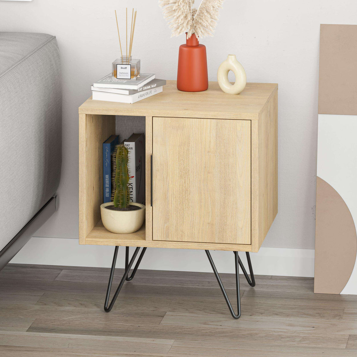 Light oak bedside table with open cubby, cabinet door, and black angled legs