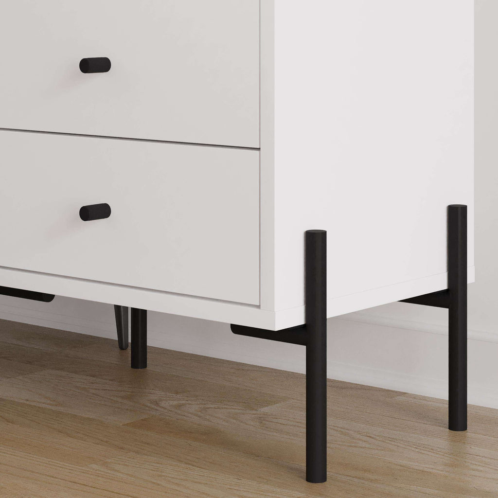 White bedside table corner detail with two drawers and black legs