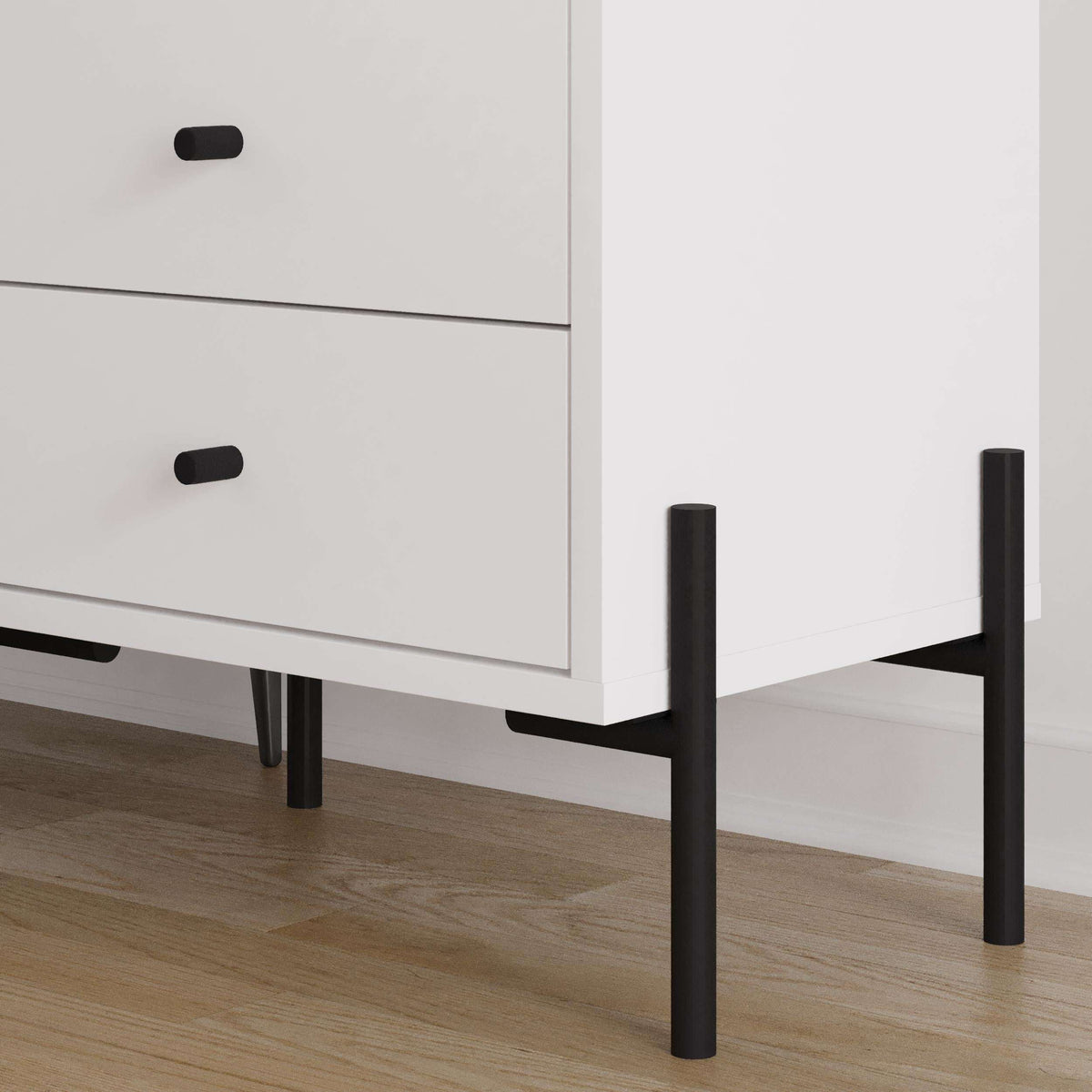 White bedside table corner detail with two drawers and black legs