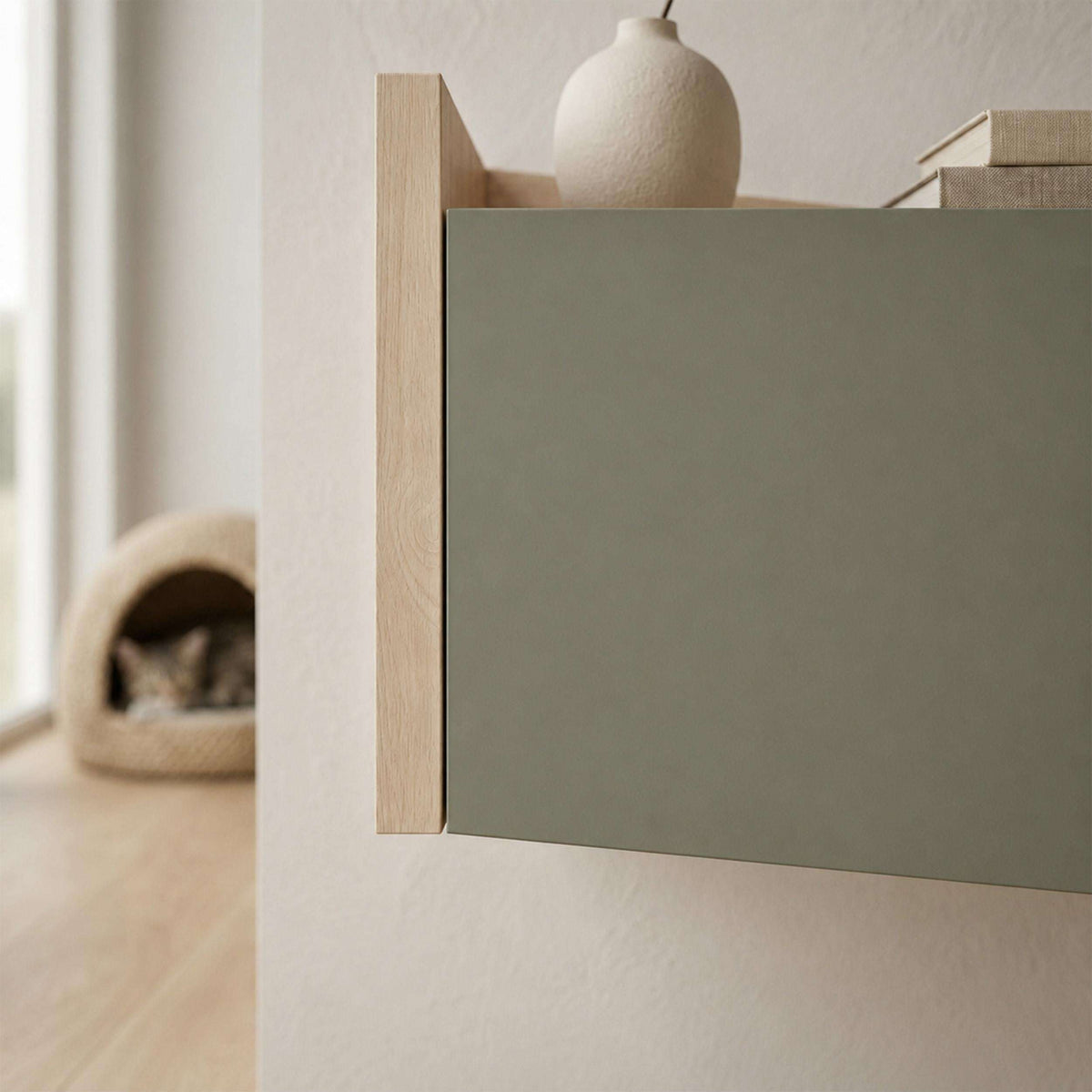 Bedside table side view with ash green drawer and open top shelf, light oak trim