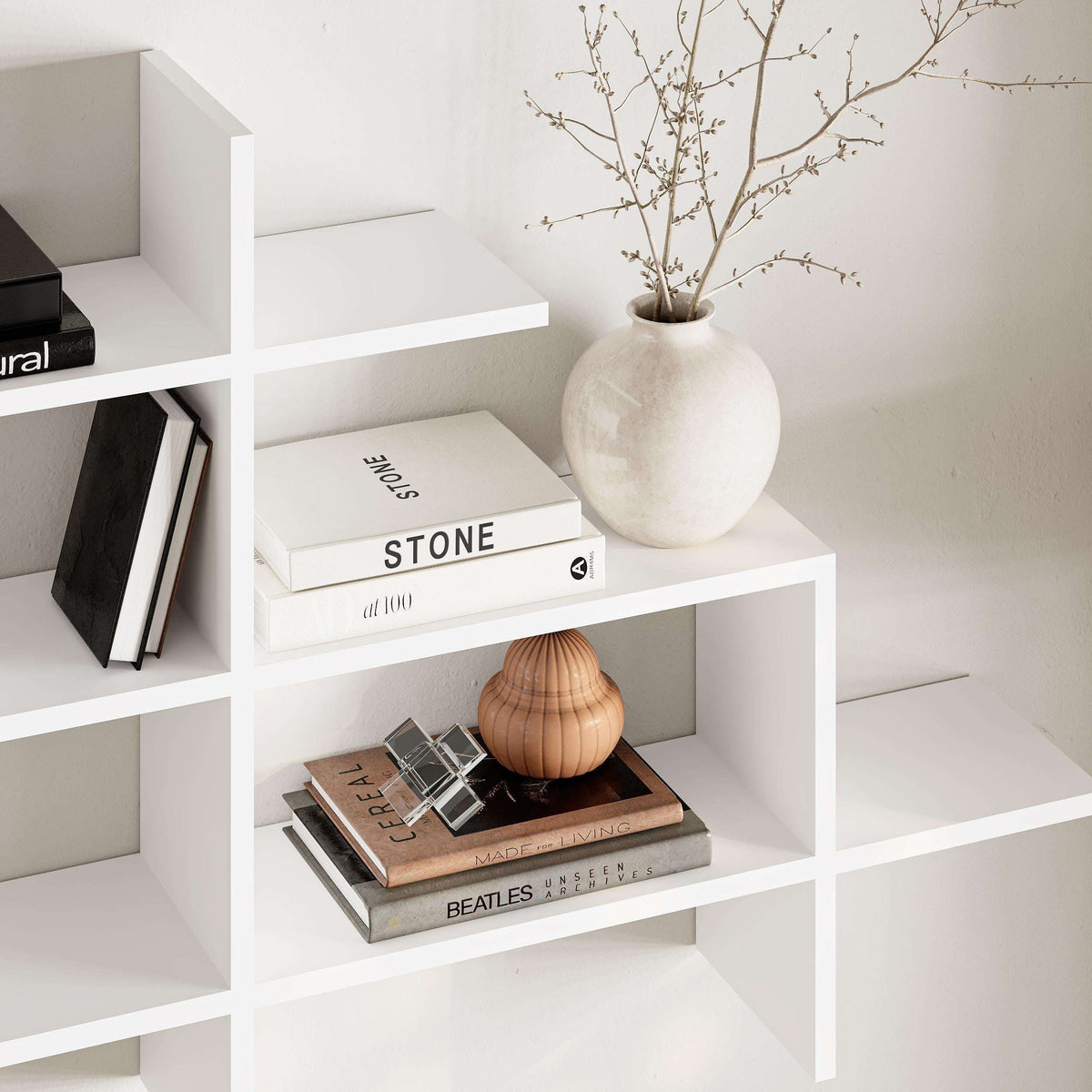 White wall-mounted bookcase with open cubby shelves and display ledge