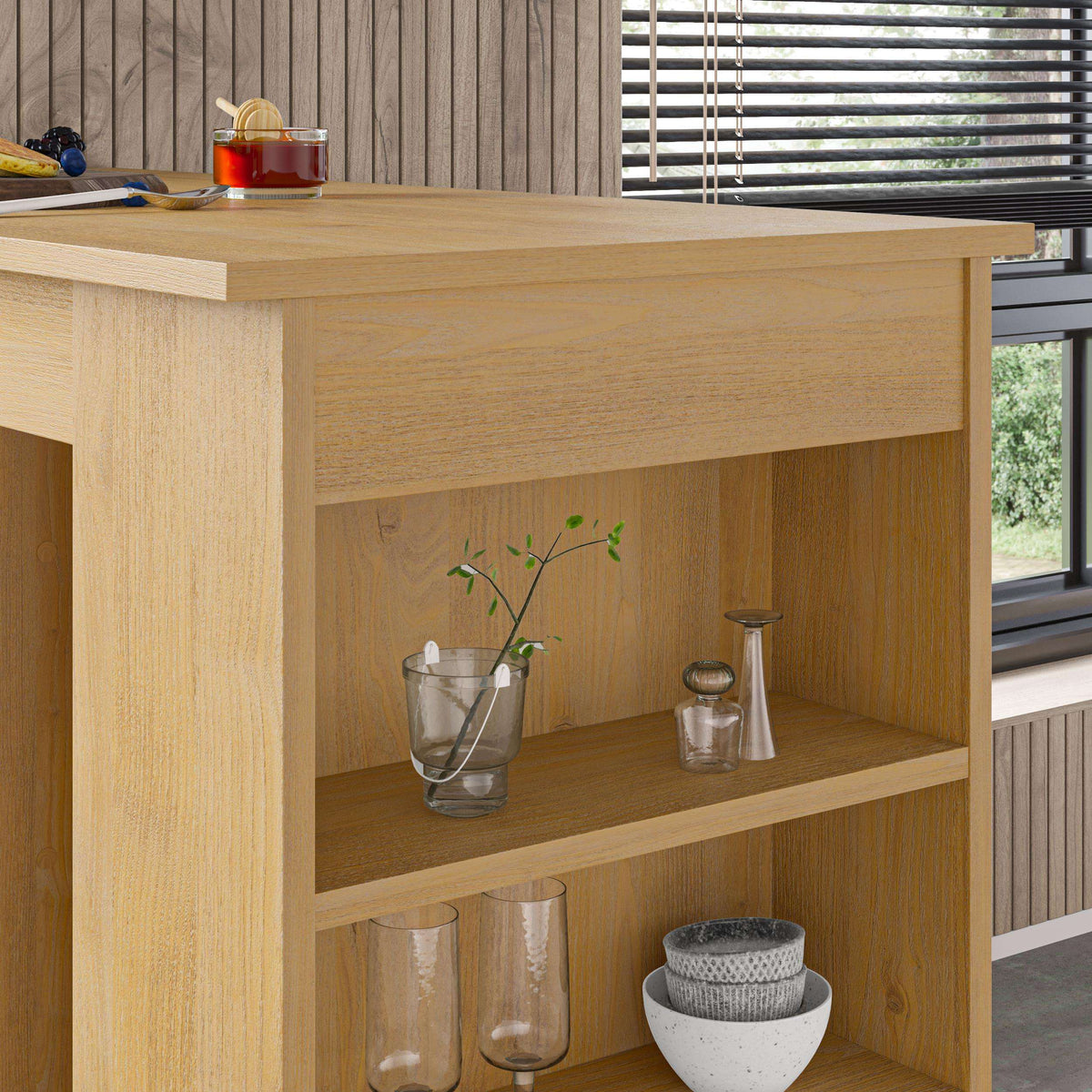 Light wood bar table with open storage shelves and glassware, bowl, and vase