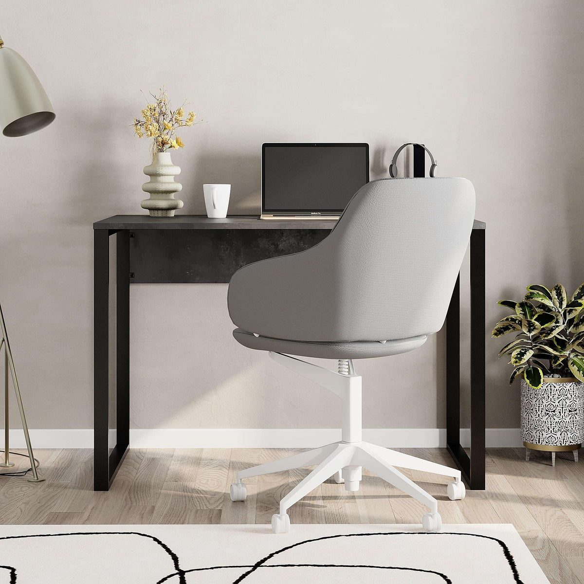 Dark working table with black frame and swivel chair in front
