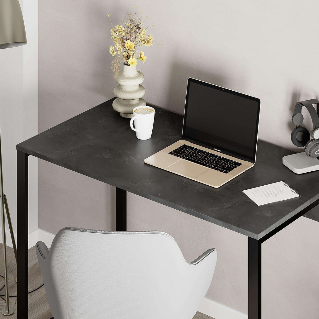 Dark working table with laptop setup on top and black metal base