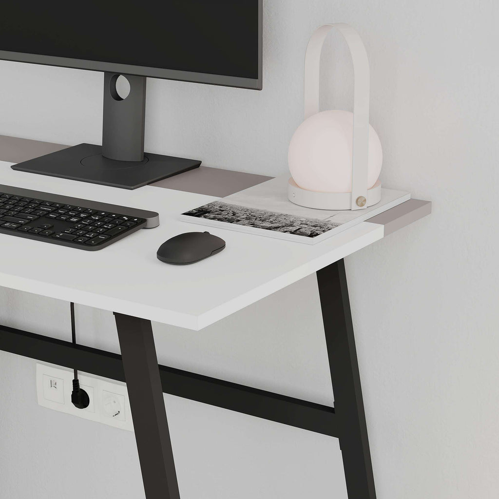 White study desk with monitor and keyboard on top, dark legs and power outlets