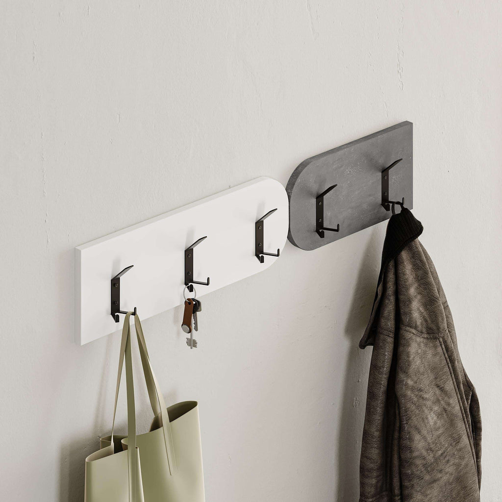 Wall-mounted coat rail with hooks and hanging items above a padded bench