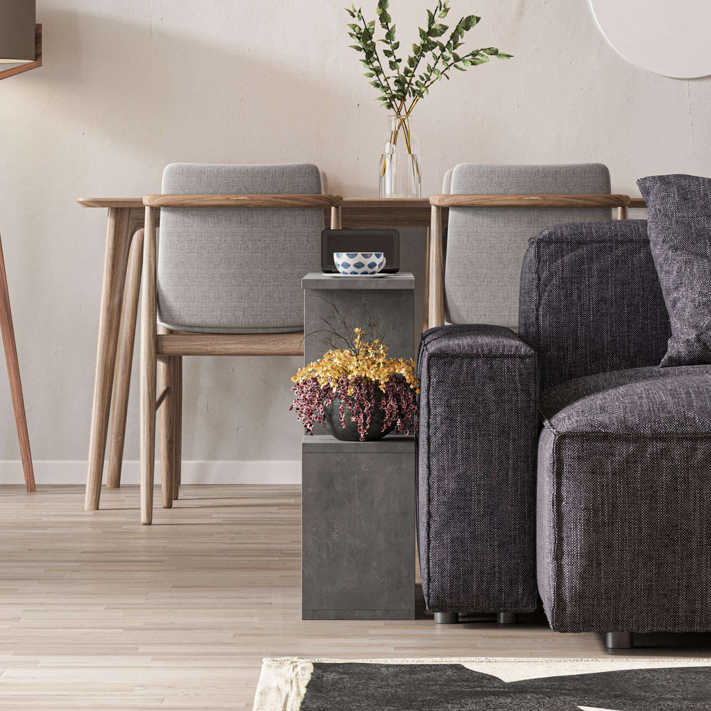 Modern side table with 4 open shelves, gray finish next to upholstered seating