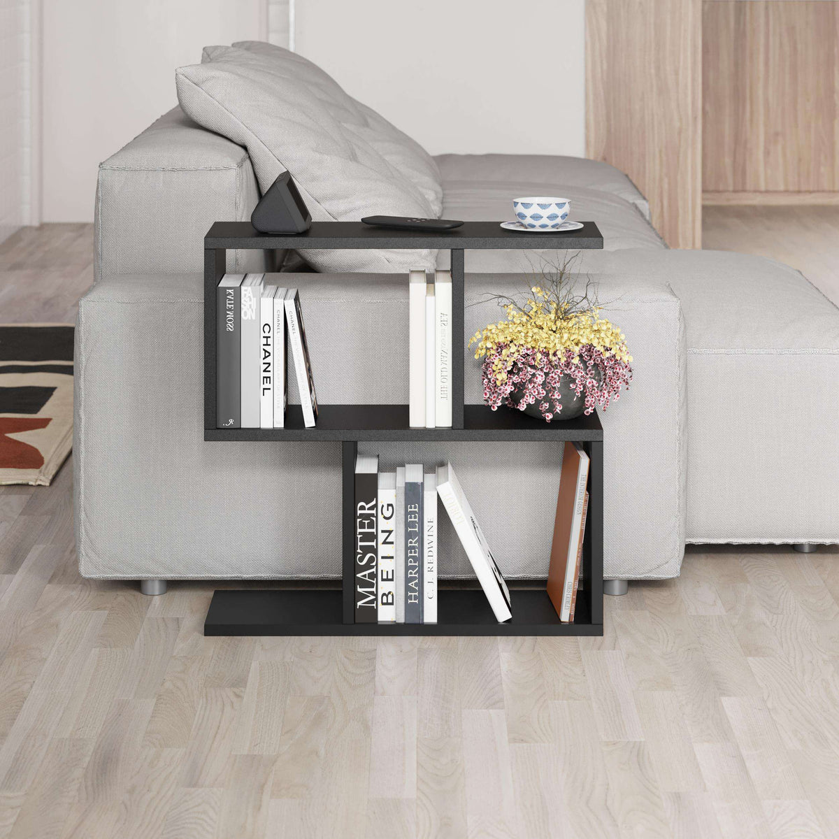 Modern side table with four open shelves in light gray, sofa-side styling with books