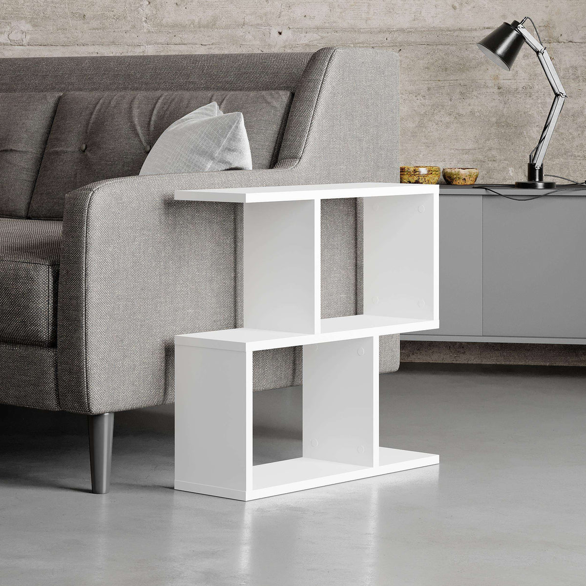 Modern side table with four open shelves in white, open cubbies beside a sofa