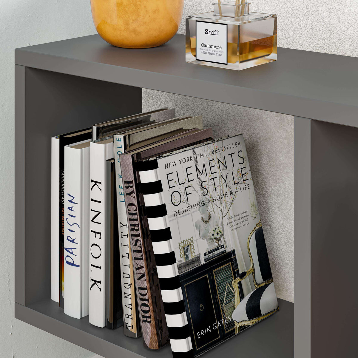 Grey modern side table with 4 open shelves, books stacked on the lower shelves