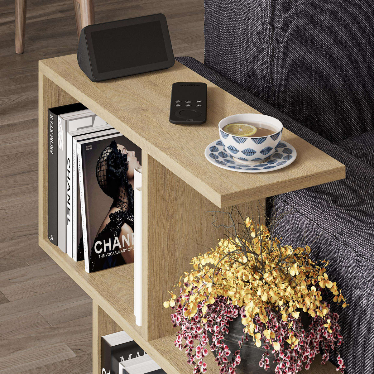 Modern side table with four open shelves in light wood, close view with tablet and cup