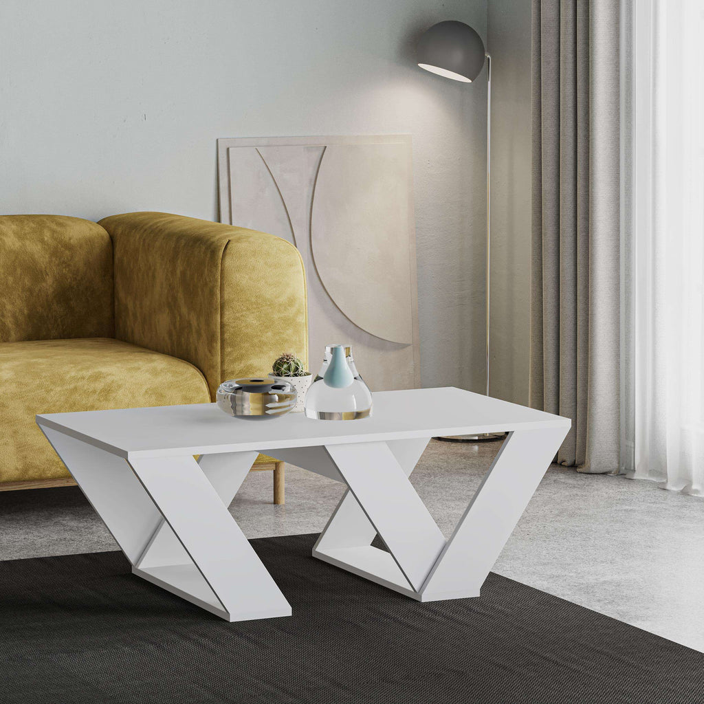 White modern coffee table with geometric base, rectangular top, decor on surface