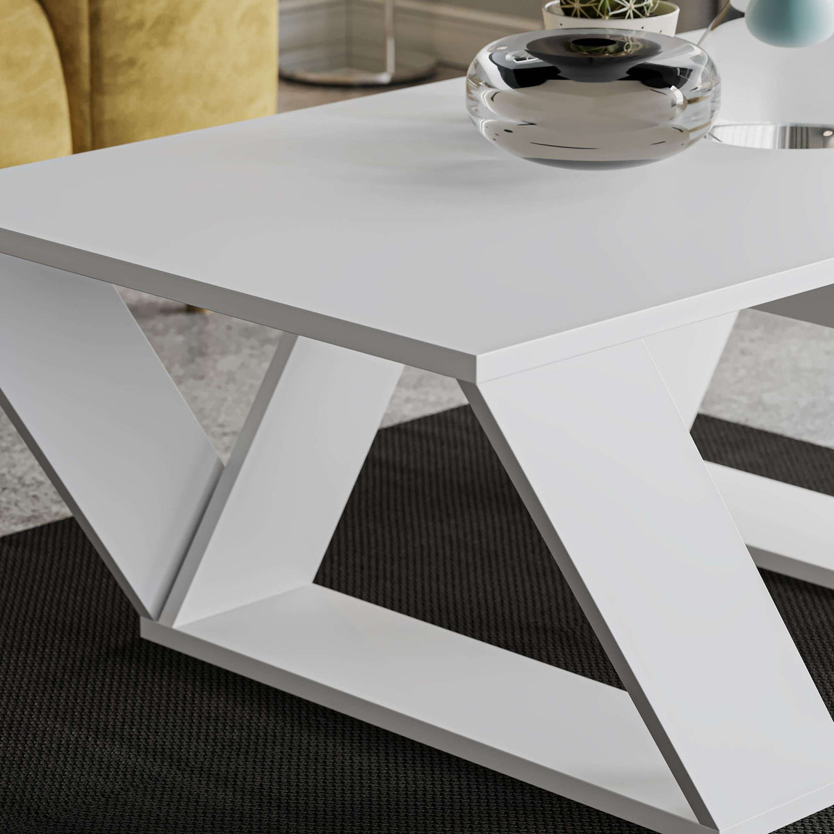 White coffee table close-up of smooth top and angular cross-pattern legs