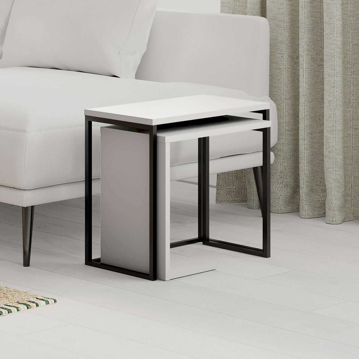 White nesting side table set with black metal frame and open lower shelf