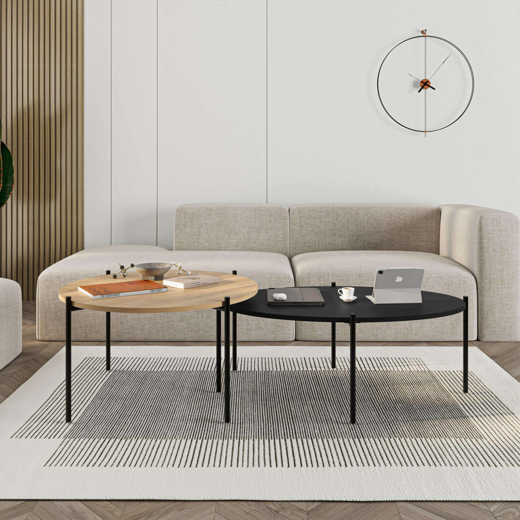 Nested coffee table set with light wood round top and dark oval top, black metal legs.