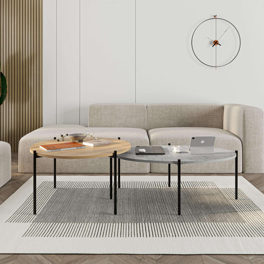 Coffee table set with two nested tables: light wood round top and dark oval top on legs.