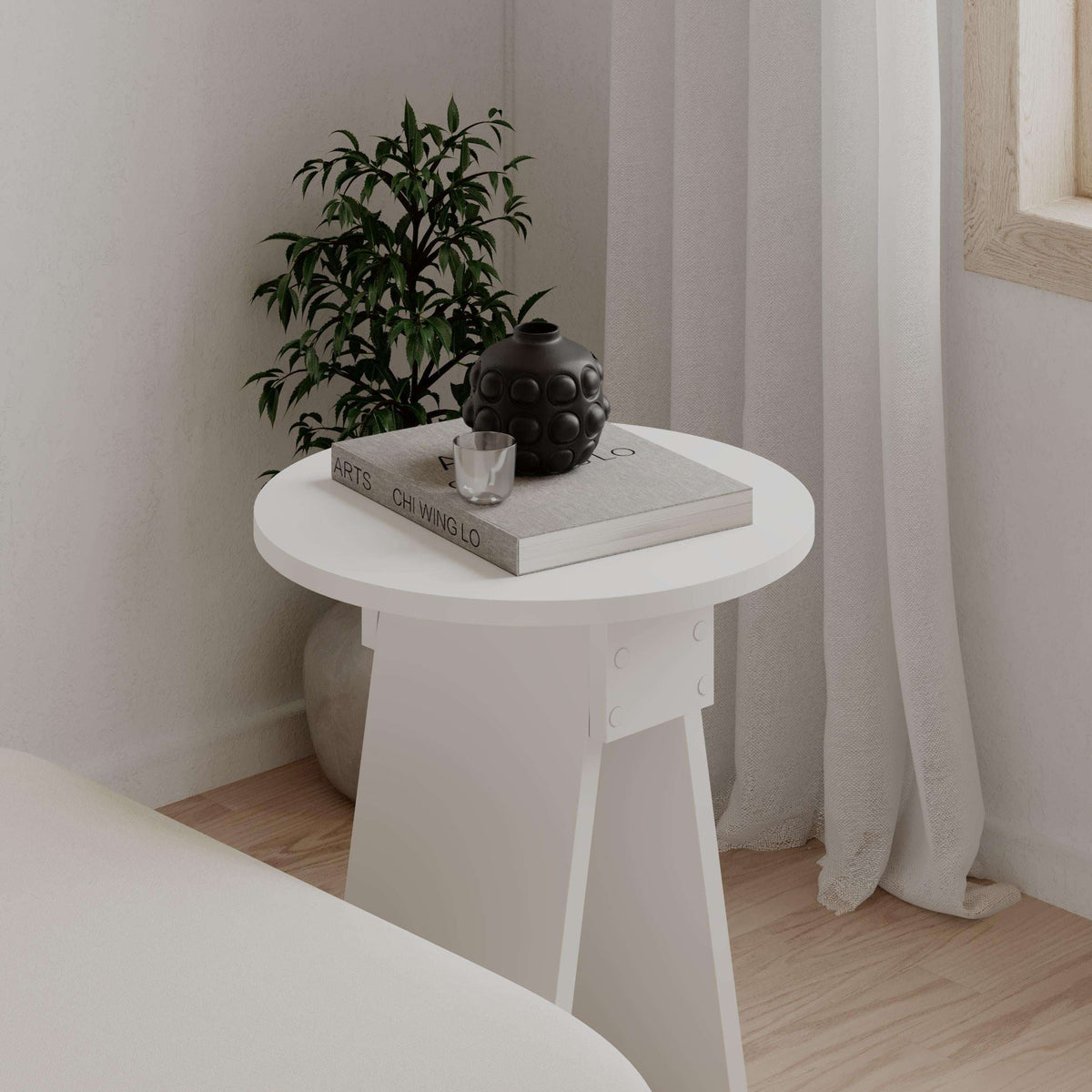 Modern round white side table with smooth top and four-sided pedestal base