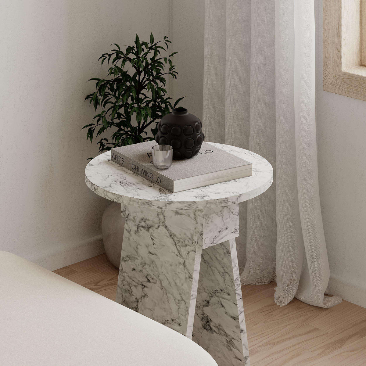White marble-look round side table with veined top and four slender legs
