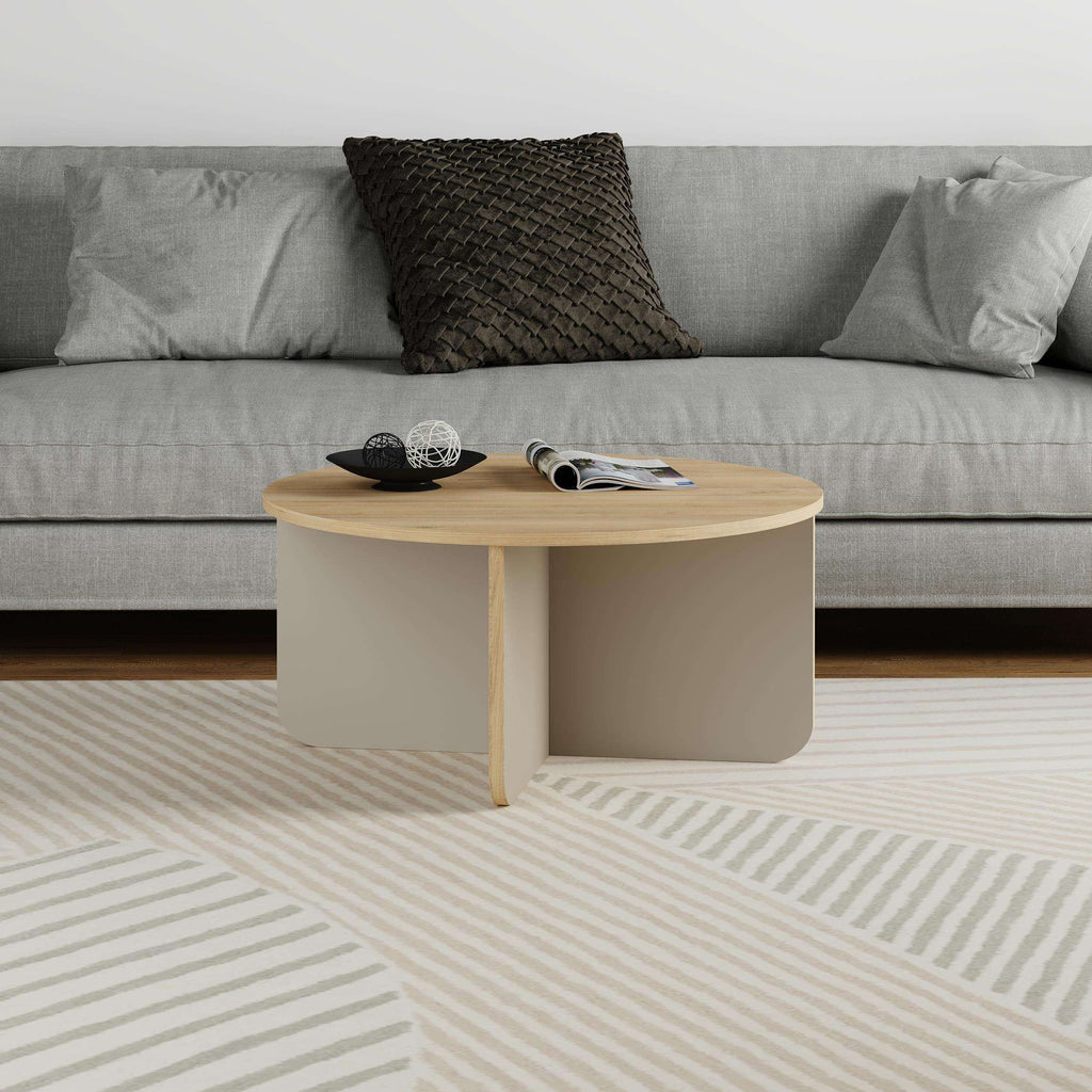 Round coffee table with light wood top and beige curved sides in a living room.