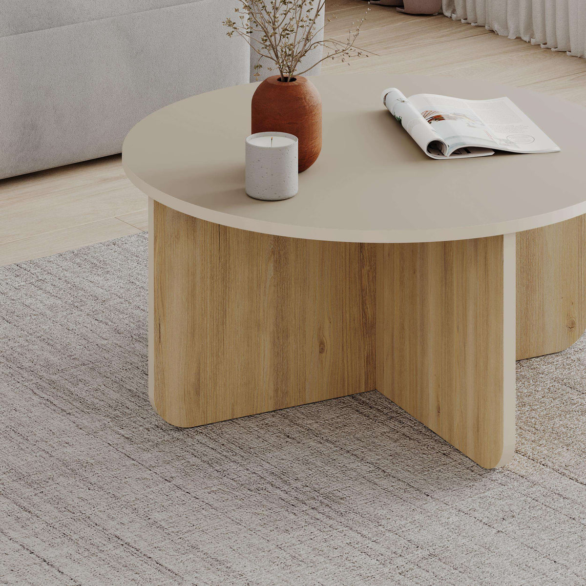 Round coffee table with light oak wood sides and curved apron