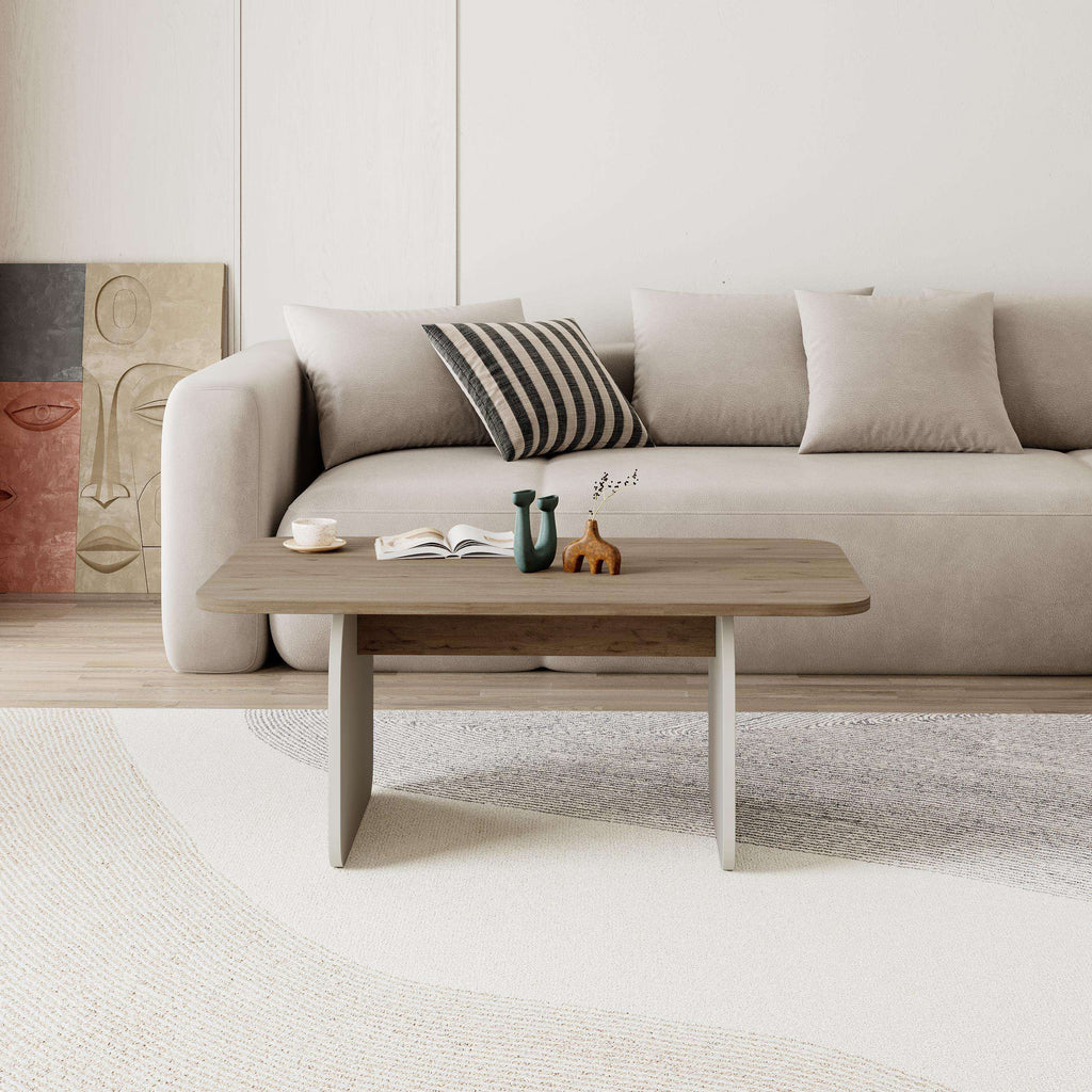 Light oak radius coffee table with rounded top and four curved legs