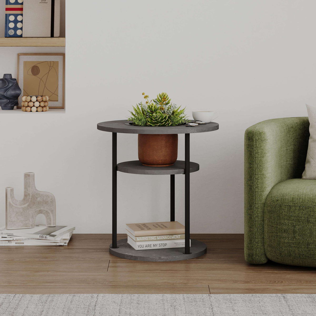 Round side table with shelf, dark grey round shelves and black legs beside green sofa.