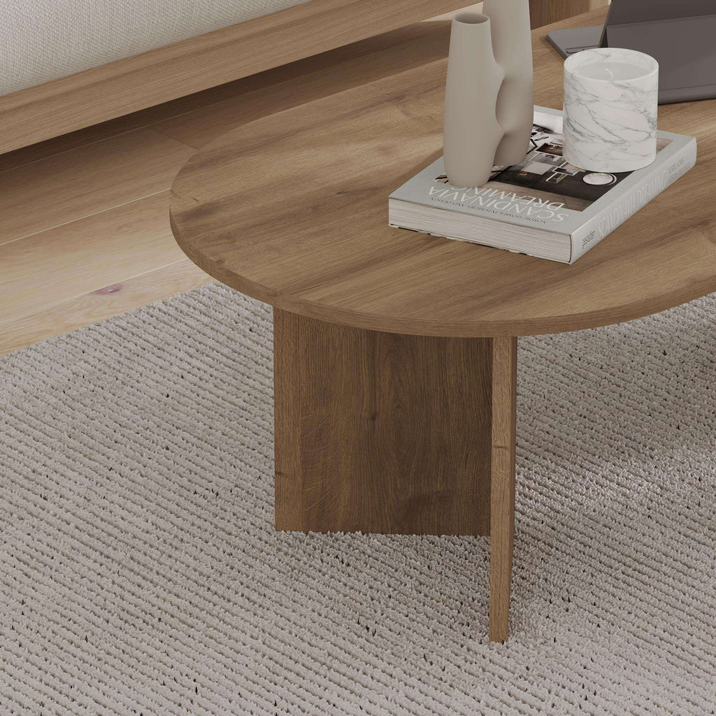 Oak-tone oval coffee table with pedestal-style leg and rounded wood top
