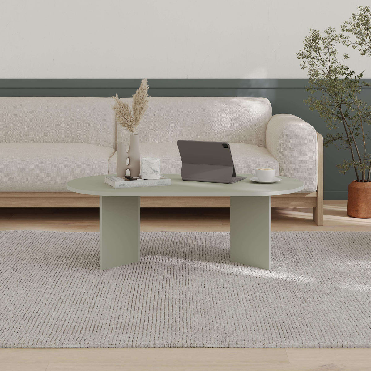 Oval coffee table in soft green with smooth tabletop and straight legs