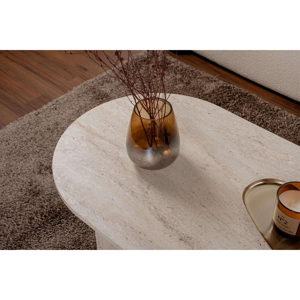 Light stone oval coffee table with slender legs and smooth rounded tabletop