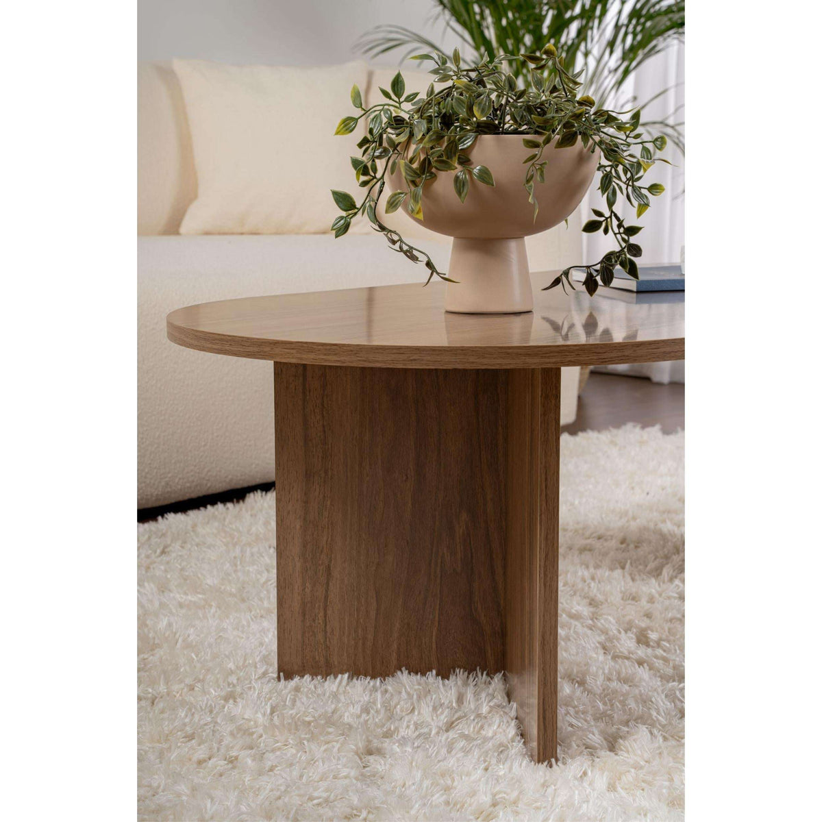 Oval walnut coffee table with rounded top and vertical side panels