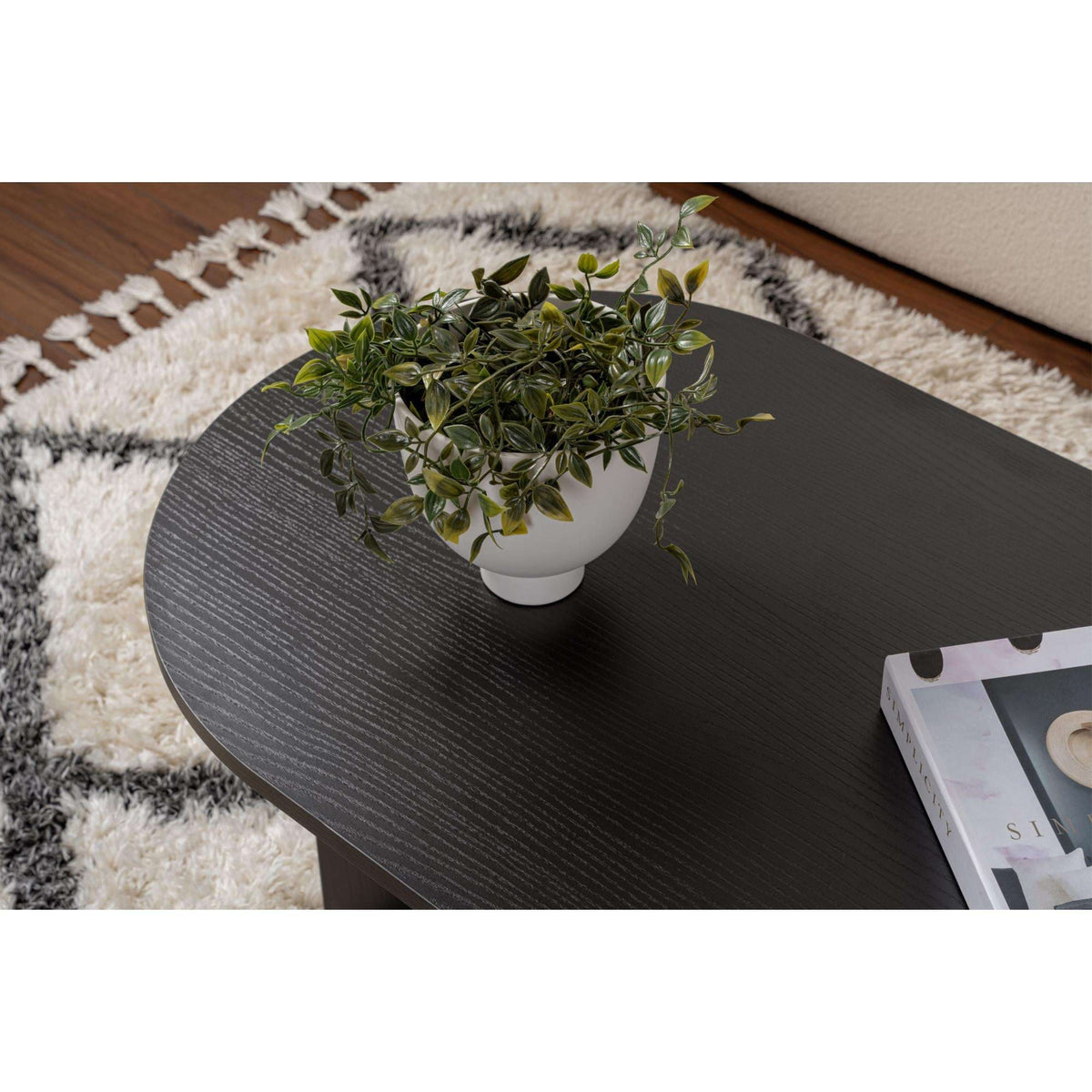 Dark oval coffee table top with subtle grain texture and curved edge