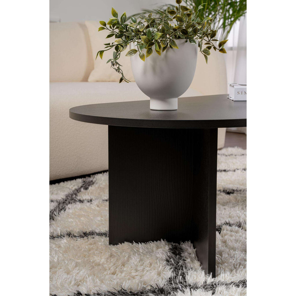 Dark oval coffee table with tapered legs and matte tabletop finish