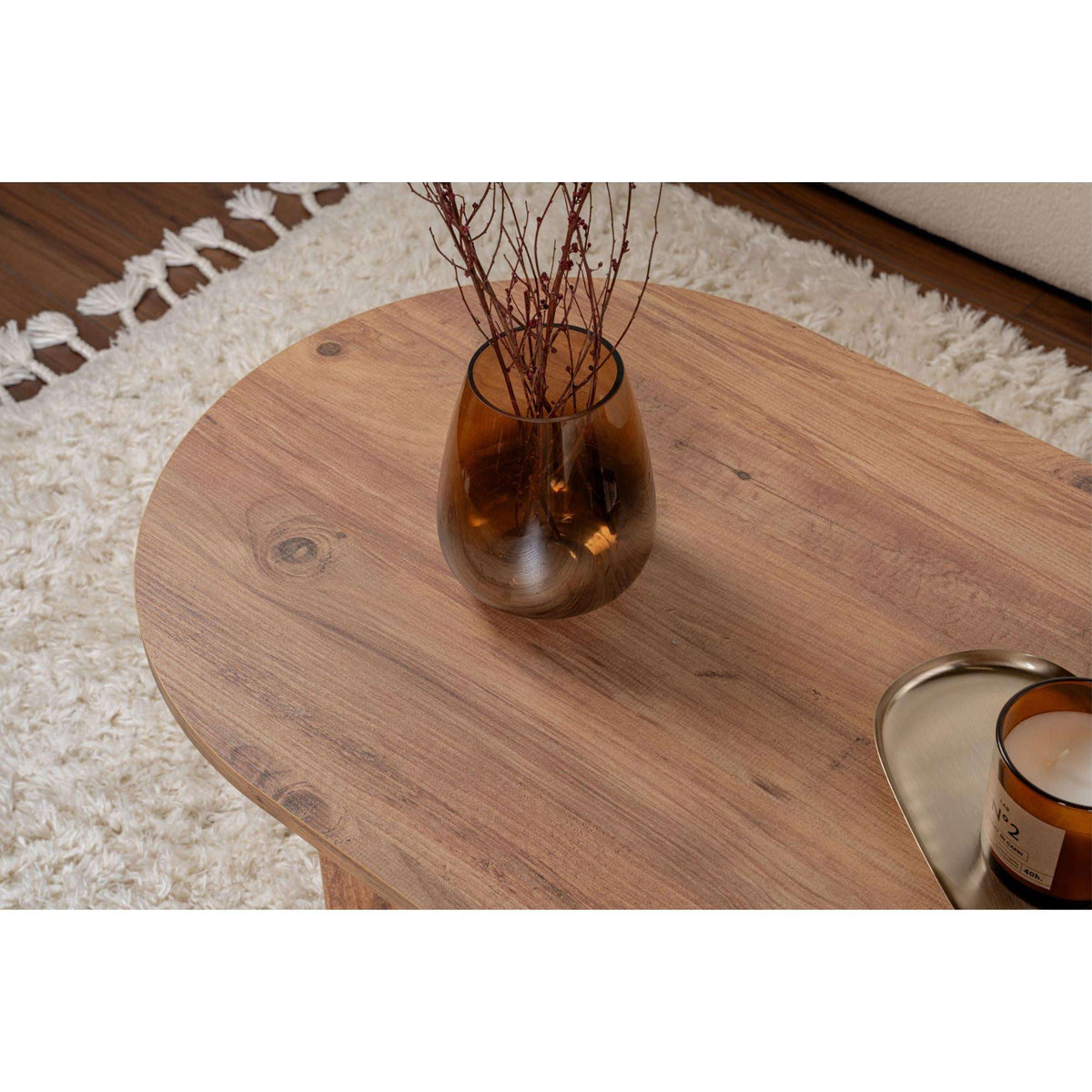 Close-up of natural wood oval coffee table top with central leg support.