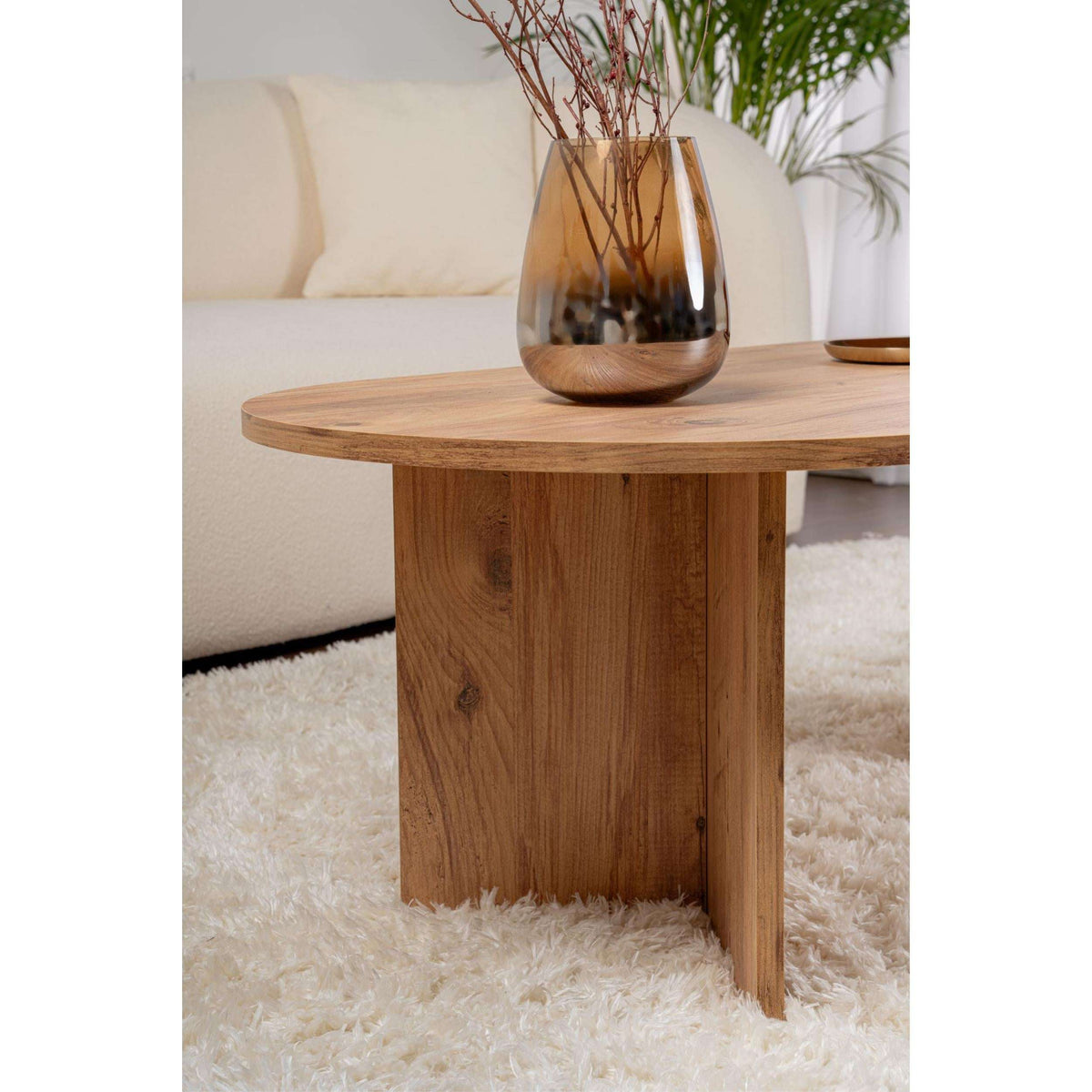 Light brown oval coffee table with smooth tabletop and vertical front support