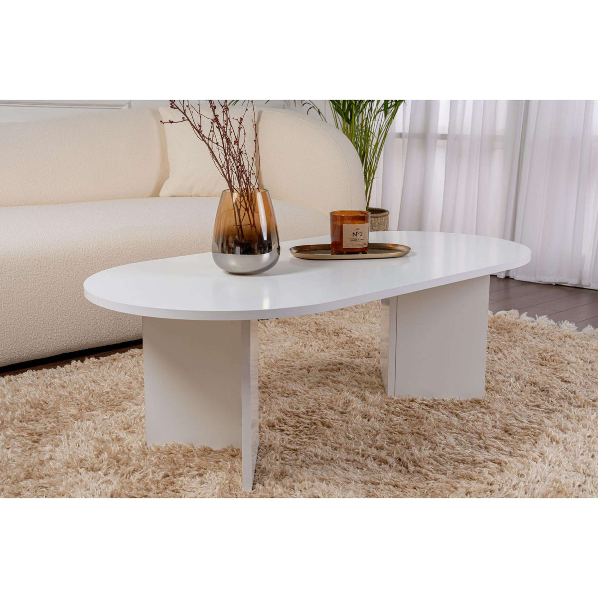 White oval coffee table with rounded tabletop edge and straight leg frame.