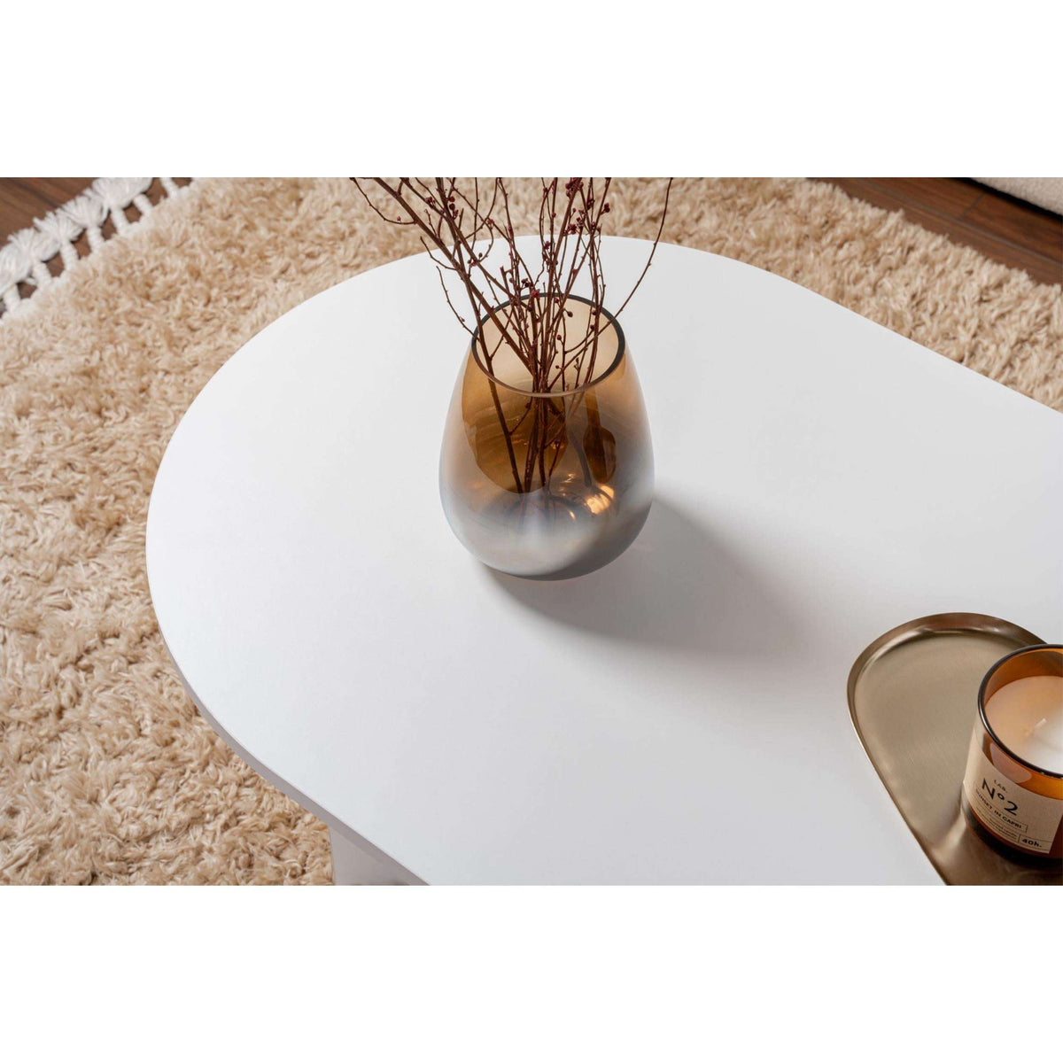 Oak oval coffee table with smooth white tabletop and tapered base legs.