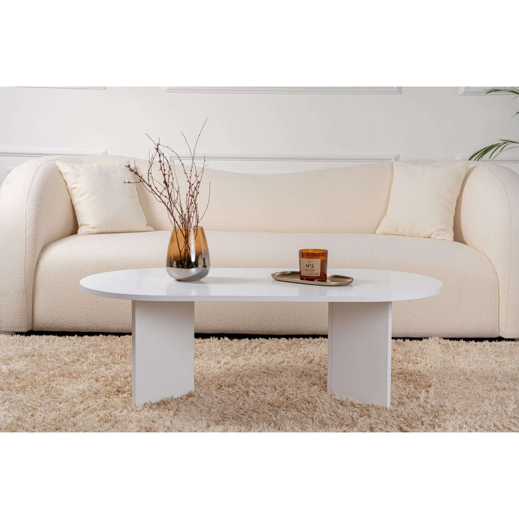 Oak oval coffee table with smooth round surface and four tapered legs.
