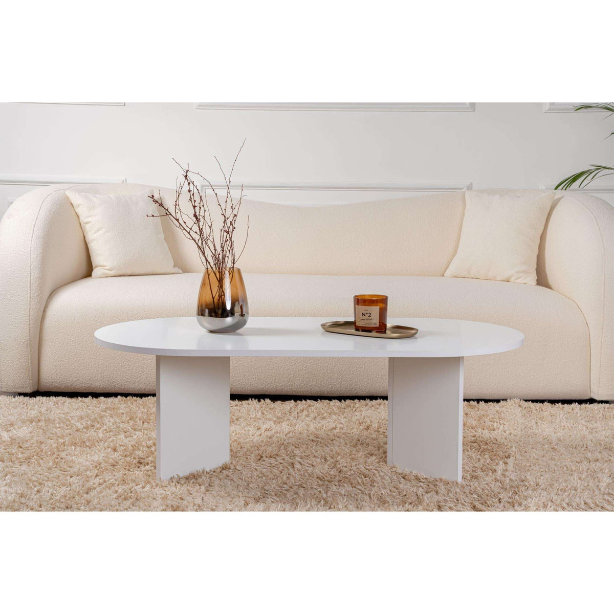 Oak oval coffee table with smooth round surface and four tapered legs.