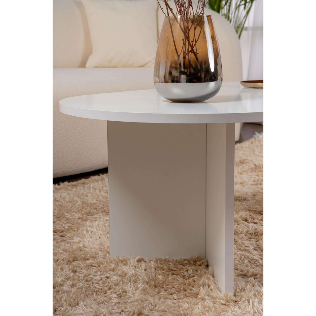 White oval coffee table side view with tapered tabletop support legs.