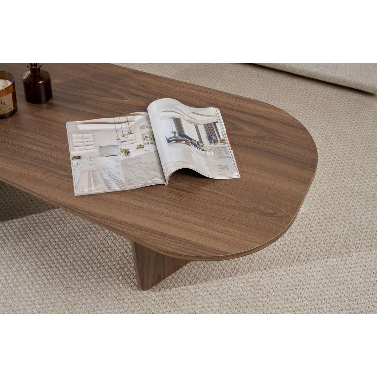 Oval coffee table in walnut-toned wood with rounded edges and tapered legs