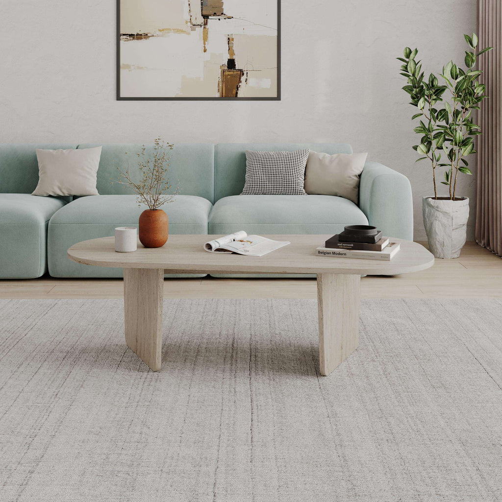 Light wood oval coffee table with rounded top and two-piece pedestal base