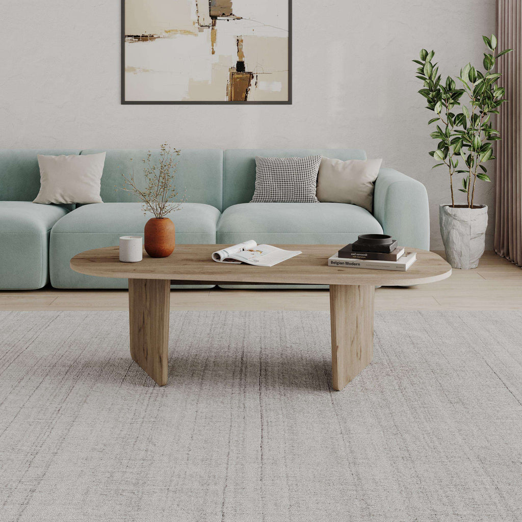 Modern oval coffee table in light oak wood with tapered legs