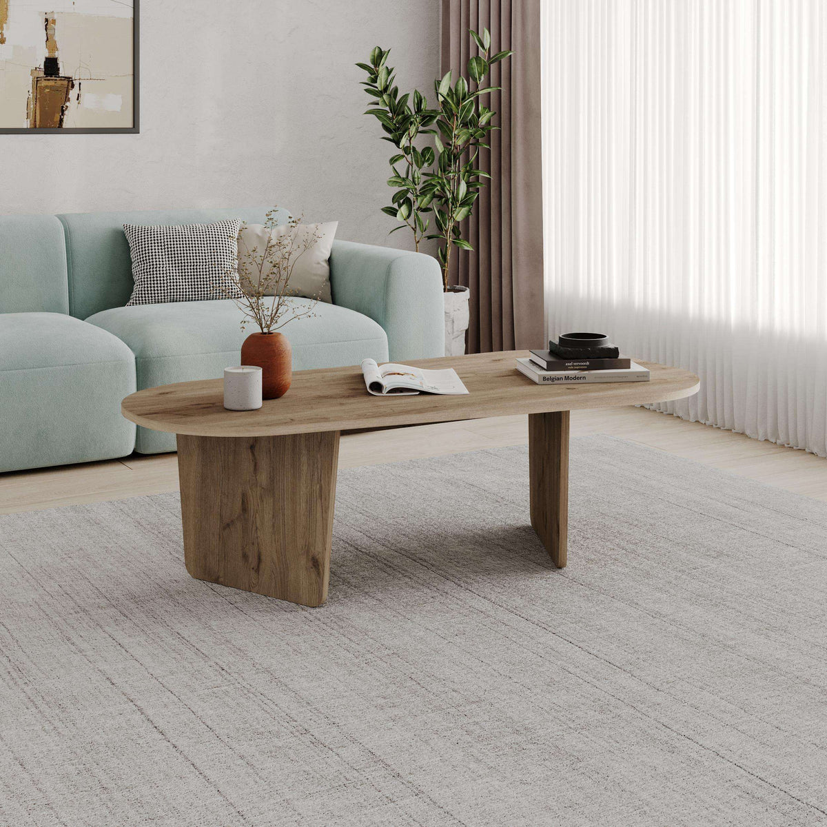 Light wood oval coffee table with tapered sides and a modern pedestal base
