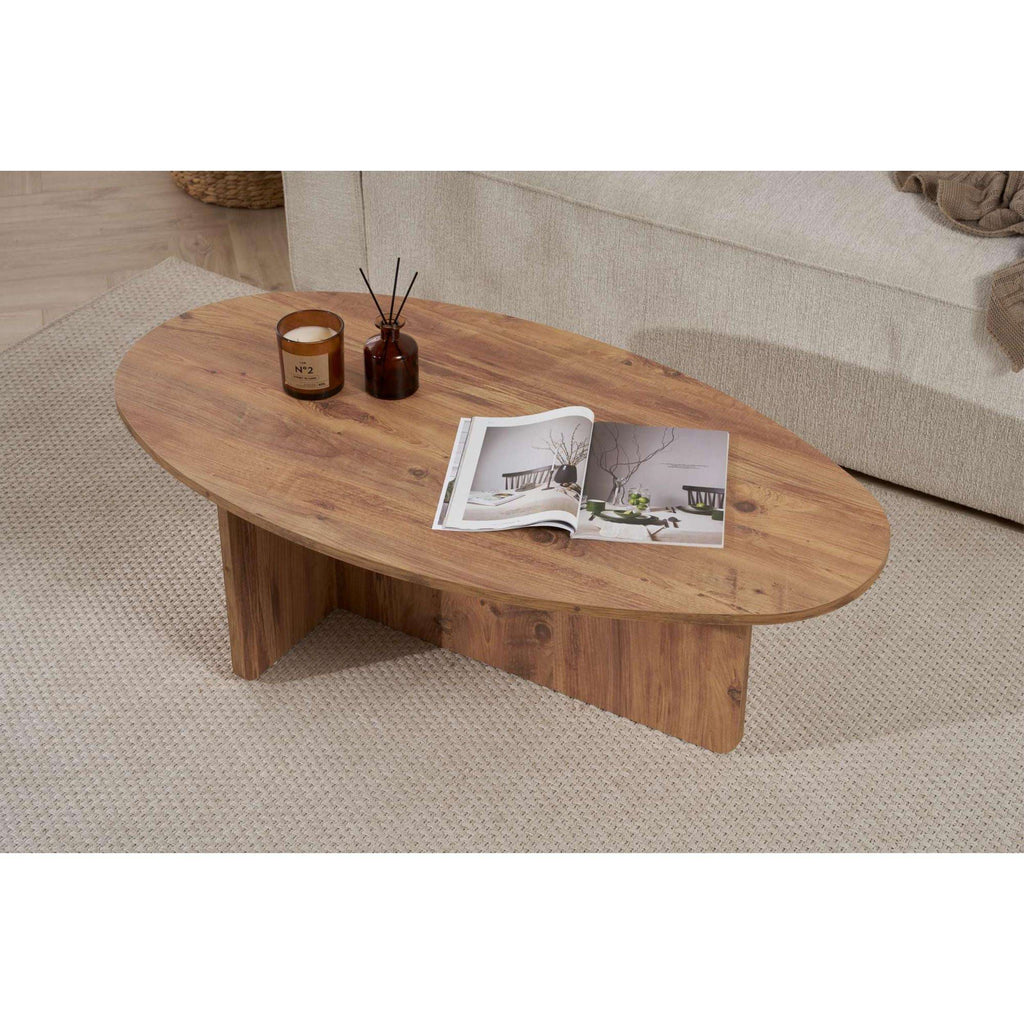 Oval dark wood coffee table with rounded top, candles, and an open magazine.
