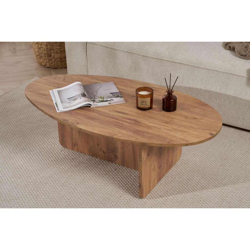 Oval coffee table in light pine wood with warm tone and rounded, low legs.