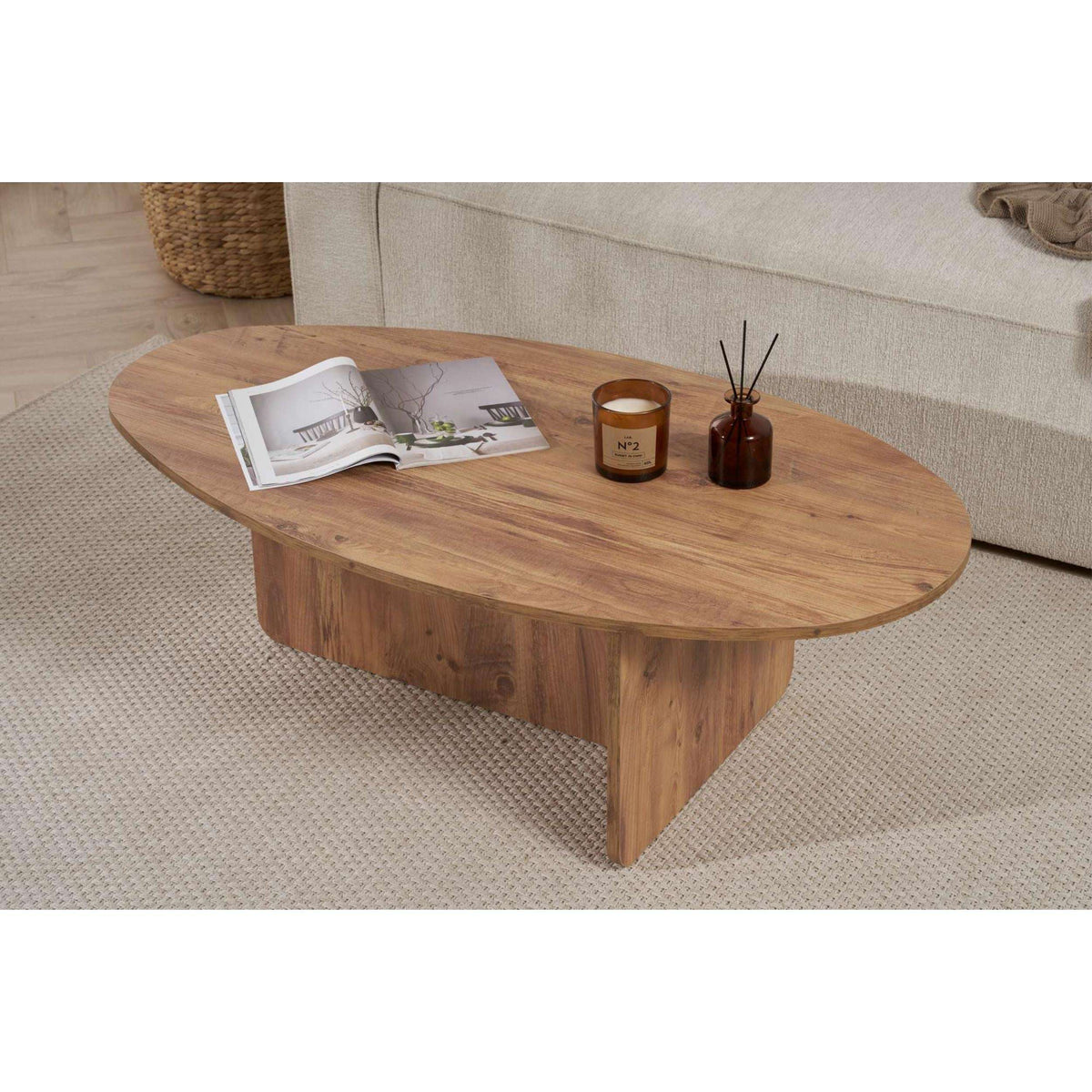 Oval coffee table in light pine wood with warm tone and rounded, low legs.