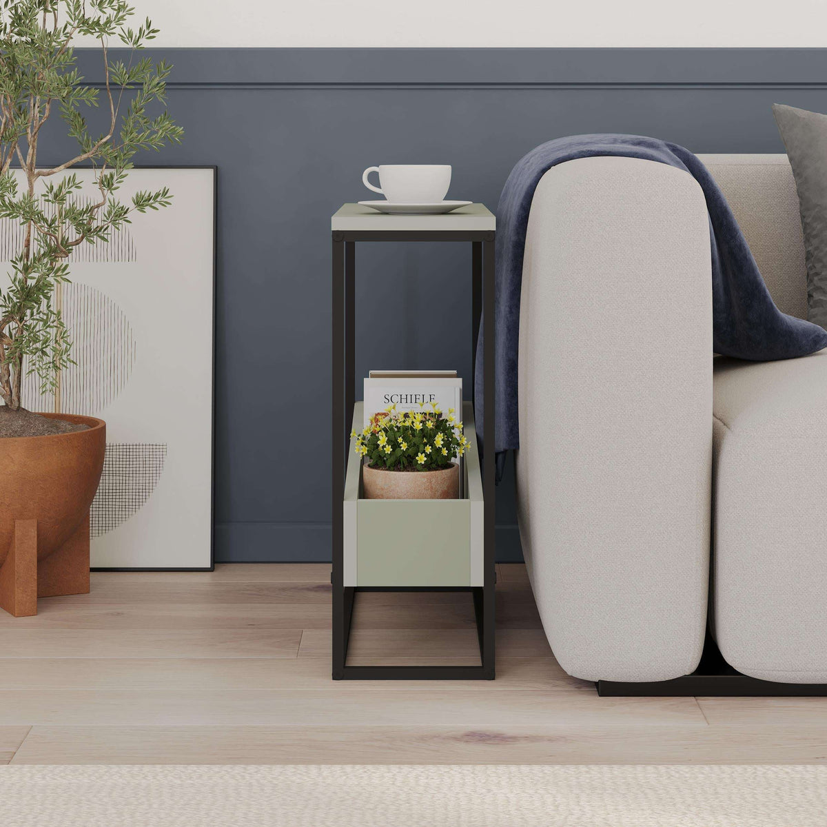 Slim side table with dark frame and open lower shelf; cup and planter on top