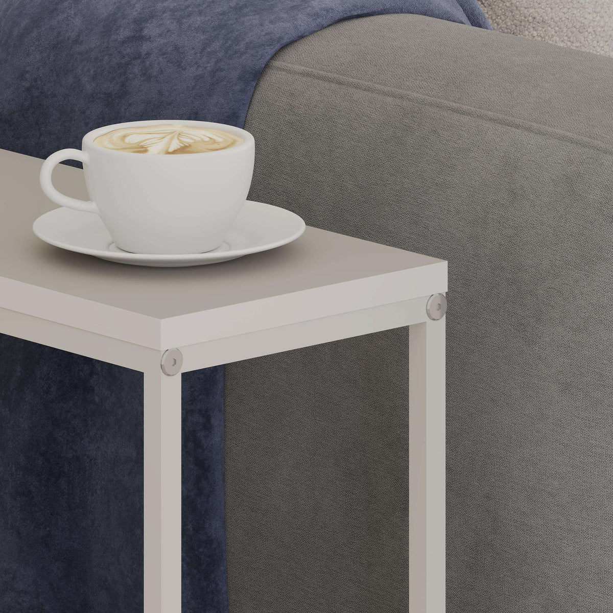 Slim side table with light top and corner details; cup on the tabletop