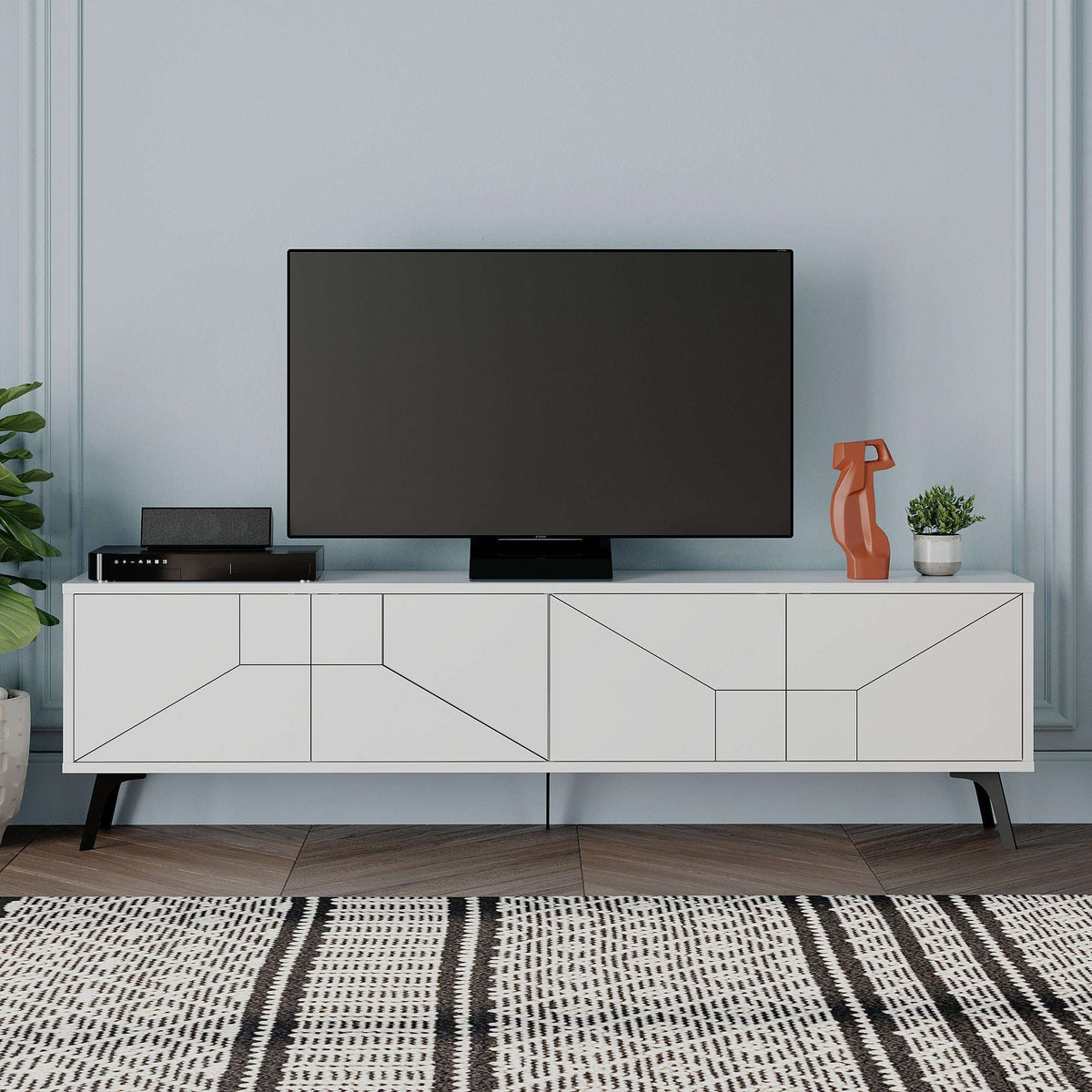 White TV stand with storage cabinets and geometric panel doors, black TV area.