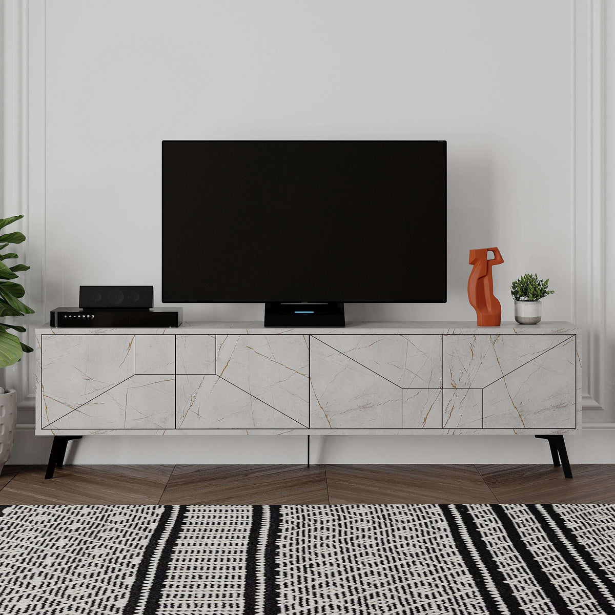 White modern TV stand with open shelves, geometric cabinet fronts, black TV on top.